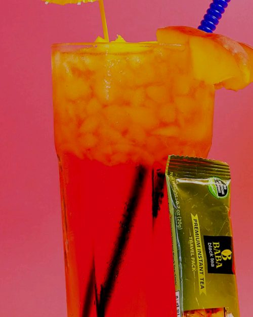 Iced peach tea in a tall glass with a Baba sachet